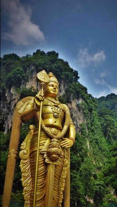 a golden statue in front of some mountains