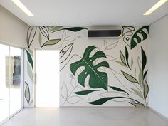 a white room with green leaves painted on the wall