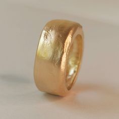 a close up of a gold ring on a white surface