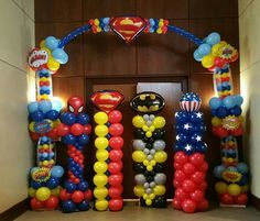 an entrance decorated with balloons and decorations for a superman themed birthday or baby's first birthday