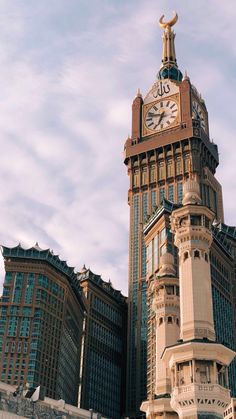 a tall clock tower in the middle of a city with buildings around it and a sky background