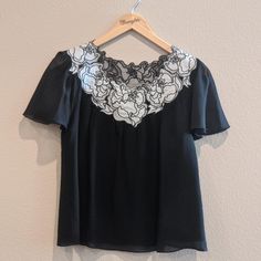 Beautiful Black Silk, Short-Sleeved Blouse With Floral Embroidered Neckline From Vivienne Tam. Details: - 100% Silk Size: 8 Condition: Never Worn, New Without Tags *The Color Of The Item May Vary Due To Photo Lighting & Device Setting* From Smoke-Free, Pet-Free Home. Contact For Any Additional Information. Black Embroidered Formal Tops, Formal Black Embroidered Tops, Formal Short Sleeve Top With Lace Trim, Short Sleeve Tops With Lace Trim For Work, Short Sleeve Blouse With Lace Trim For Work, Elegant Black Tops With Floral Embroidery, Elegant Spring Blouse With Embroidered Neckline, Fitted Blouse With Embroidered Neckline And Short Sleeves, Elegant Blouse With Embroidered Neckline For Spring