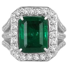 A luxurious emerald and diamond cocktail ring. This remarkable masterpiece features a large, fine-quality natural emerald cut emerald from the origin of Zambia. The gemstone showcases a rich dark emerald-green color, excellent-very good clarity, luster, and countless other outstanding characteristics. The emerald also has a visibly imperfect internal fissure that can be seen in one of its corners as no natural emerald is flawless. Surrounding the center gem is a brilliant round cut diamond halo, Emerald Cocktail Ring, Large Engagement Rings, Emerald Cocktail, Statement Engagement Ring, Prong Engagement Rings, Ring Emerald Cut, Popular Engagement Rings, Diamond Cocktail Ring, Diamond Cocktail Rings