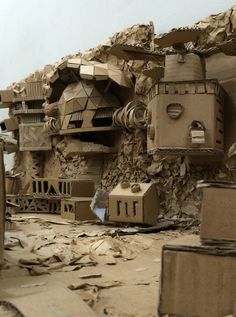 some cardboard boxes are stacked on top of each other in front of a pile of rubble