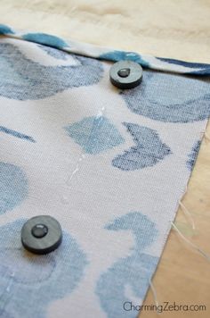 the fabric is being sewn together with buttons