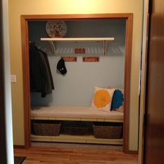 a room with a bench, coat rack and two baskets