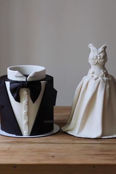 two cakes made to look like wedding gowns and tuxedos are sitting on a table