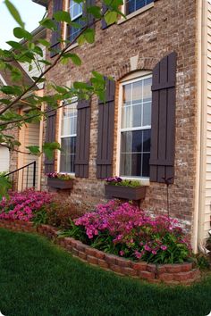 a brick building with flowers in the window boxes