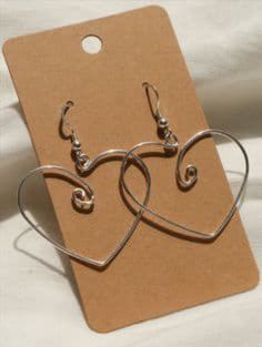 pair of heart shaped earrings sitting on top of a card