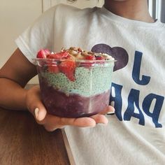 a person holding a bowl of food on top of a table