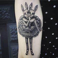 a woman's arm with a rabbit tattoo on it and an image of a dress