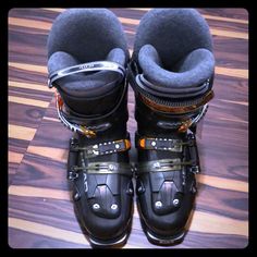 a pair of ski boots sitting on top of a wooden floor