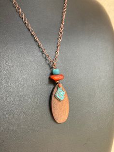 A teardrop shaped pendant of walnut wood, accented with a copper plated spiral charm with a blue green patina, carnelian, and Java glass hangs from from delicate copper diamond shaped long and short chain. Perfect worn alone, or layered with another necklace, such as the Mixed Media Carnelian Necklaces in the shop. See last photo for more in the series. ~Long Carnelian Mixed Median Necklace with Feather Pendant https://www.etsy.com/listing/1058619193/orange-carnelian-necklace-long-necklace ~Mixe Artisan Teardrop Copper Necklace, Bohemian Teardrop Pendant Copper Necklace, Bohemian Copper Teardrop Pendant Necklace, Spiritual Teardrop Copper Necklace, Copper Necklace Pendant, Carnelian Earrings, Necklace Orange, Necklace Wood, Orange Carnelian