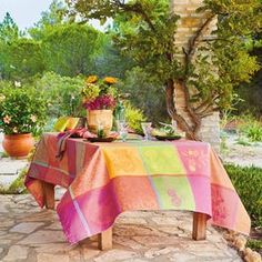 the table is covered with colorful cloths and flowers