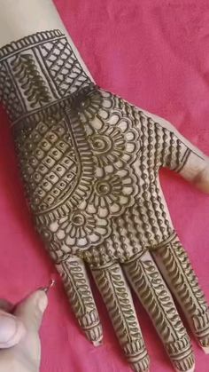 someone is getting their hands painted with henna