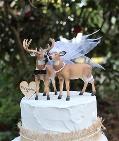 two deer figurines on top of a wedding cake