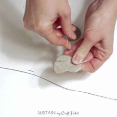 someone is making a rock with scissors and thread