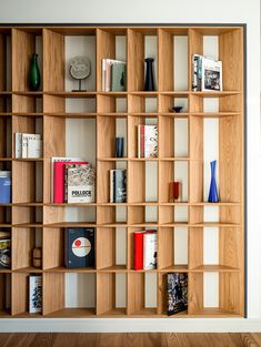 the bookshelf is made out of wood and has many different types of books on it