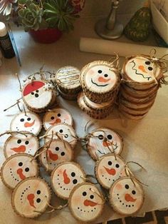 some wood slices with snowmen painted on them and christmas decorations hanging from the top