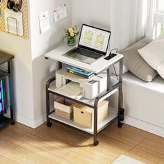 a laptop computer sitting on top of a white table next to a window sill