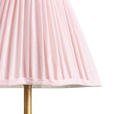 a pink lampshade with a gold base and pleated lamp shade on it