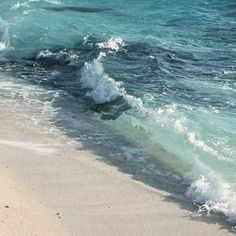 the water is splashing on the beach and waves are coming in from the shore