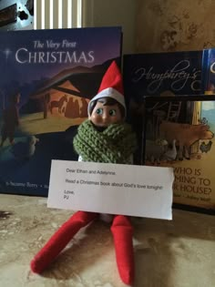 an elf is holding a sign in front of two books