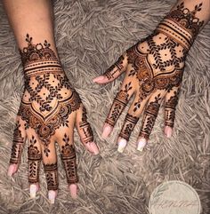 two hands with henna tattoos on them