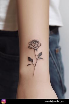 a woman's wrist with a rose tattoo on the left side of her arm