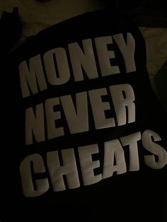 there is a black pillow with white letters on it that says money never sweats