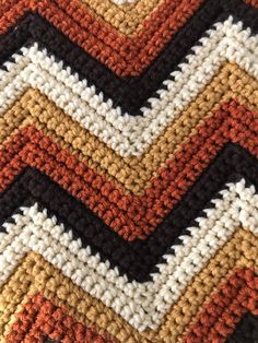 an orange, white and black crocheted blanket