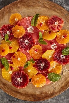 a wooden plate topped with sliced oranges and grapefruit