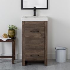 a bathroom vanity with a mirror above it and a trash can next to the sink