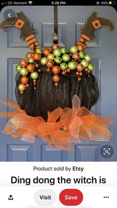 an image of a halloween door hanger with orange and green decorations on it's net