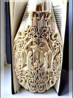 an open book with intricate carvings on the pages is shown in close up, and it appears to be folded