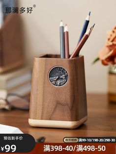 a wooden pen holder with pencils and pens in it