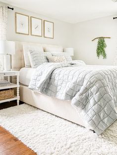 a bedroom with a white bed and two pictures on the wall