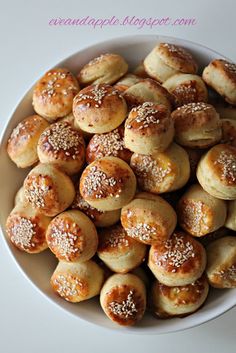 a white bowl filled with small pastries on top of a table