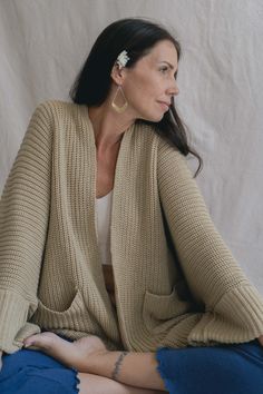 Inspired by the warm embrace of our Finnish Grandmother. We have kept its original oversized shape with its dropped shoulders. We have thoughtfully re-designed some elements and it is still ethically knitted in Bali from deadstock acrylic yarn that would otherwise have gone into landfill. We have added two deep pockets and stitches to hold the sleeves. If you prefer the loose sleeve look, you may simply cut the stitch. Oversized fit Dropped shoulder sleeves Thigh-length hemline which is slightly shortened thanks to your feedback! Perfect for throwing over the Agni Yoga range pre or post-yoga A versatile piece that can be styled up or down Can be mixed & matched with any Indigo Luna pieces This garment is created completely by a hand-cranked loom, with generational skills passed down. *This Oversized Wool Sweater For Everyday, Oversized Chunky Knit Cotton Cardigan, Oversized Knitted Beige Outerwear, Oversized Knit Acrylic Outerwear, Oversized Cream Merino Wool Sweater, Oversized Textured Knit Cotton Outerwear, Oversized Hand Knitted Spring Sweater, Oversized Hand-knitted Long Sweater, Oversized Chunky Knit Merino Wool Sweater Coat