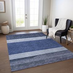 a living room area with a blue rug and black chair in front of the door