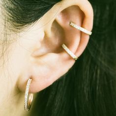 a close up of a person's ear with two small hoops attached to it