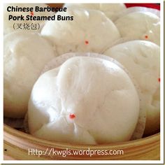 chinese steamed buns in a wooden bowl with red dots on the top and bottom