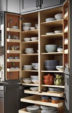 an open cabinet filled with dishes and bowls