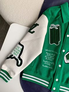 Channel the spirit of iconic streetwear with this Varsity Jacket in Green. Bold embroidery and patches create a statement look, while the classic silhouette and premium materials offer timeless appeal. Embrace the energy of Louis Vuitton Design without compromising on comfort or style. Embroidered Hooded Varsity Jacket, Retro Winter Outerwear With Embroidered Graphics, Retro Long Sleeve Outerwear With Letter Embroidery, Retro Outerwear With Embroidered Graphics For Fall, Retro Fall Outerwear With Embroidered Graphics, Sporty Embroidered Varsity Jacket For Winter, Sporty Embroidered Varsity Jacket, Urban Winter Outerwear With Letter Embroidery, Urban Outerwear With Letter Embroidery For Winter