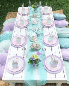 the table is set with plates and napkins for an understaffed mermaid themed party