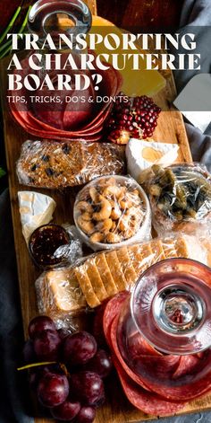 a wooden cutting board topped with lots of different types of food next to wine glasses