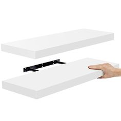 two white boxes are being held by one hand