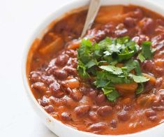 a white bowl filled with beans and cilantro