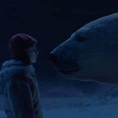 a woman standing next to a large polar bear