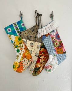 several pieces of fabric hanging from hooks on a wall